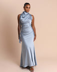 Woman wearing a light blue evening gown against a beige background