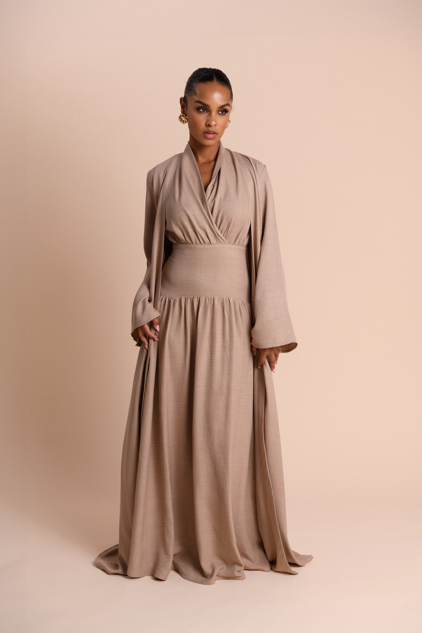 Woman wearing a beige dress against a beige background